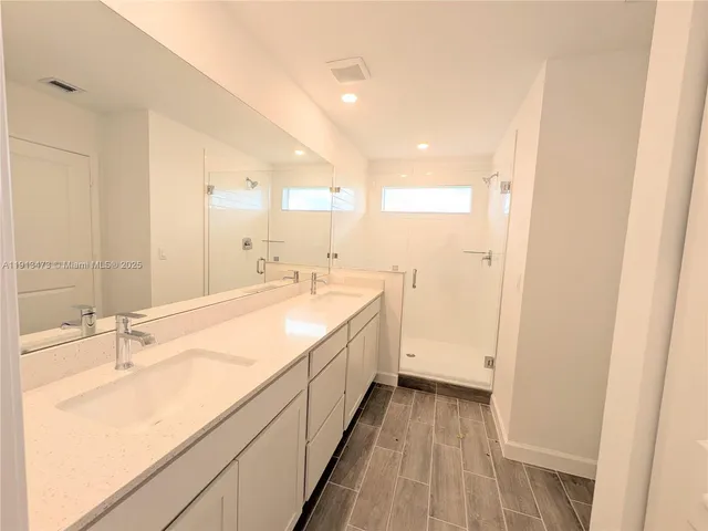 a spacious bathroom with a double vanity sink and a mirror