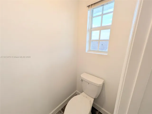 a white toilet sitting next to a window