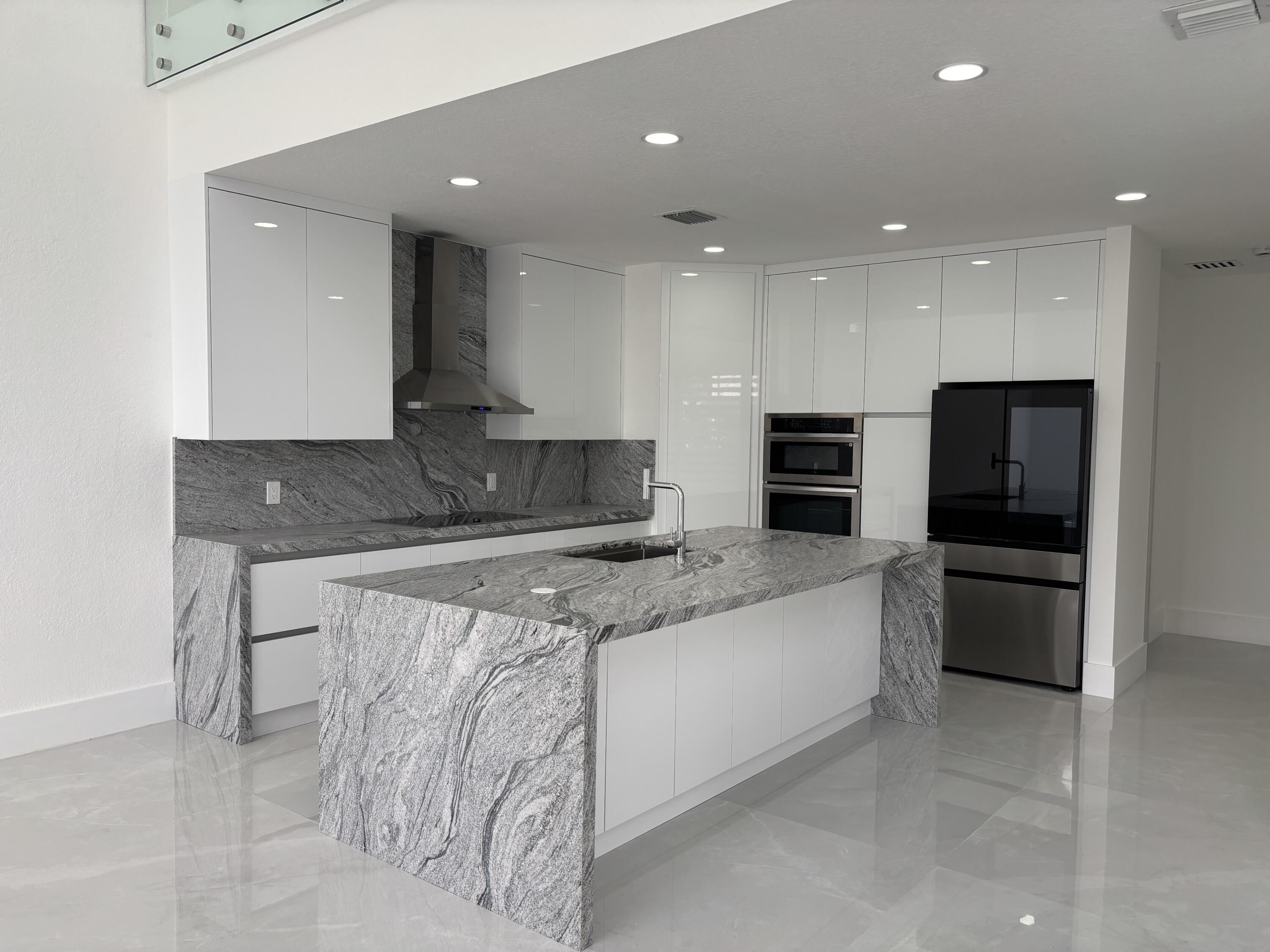 5227 Southwest 195th Terrace Miramar, FL 33029 - Photo 23 of 58 a large kitchen with stainless steel appliances kitchen island granite countertop a sink and a stove