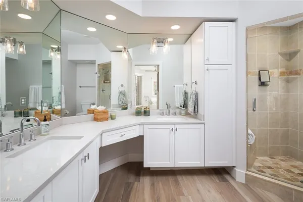 a bathroom with a double vanity sink a mirror and a shower