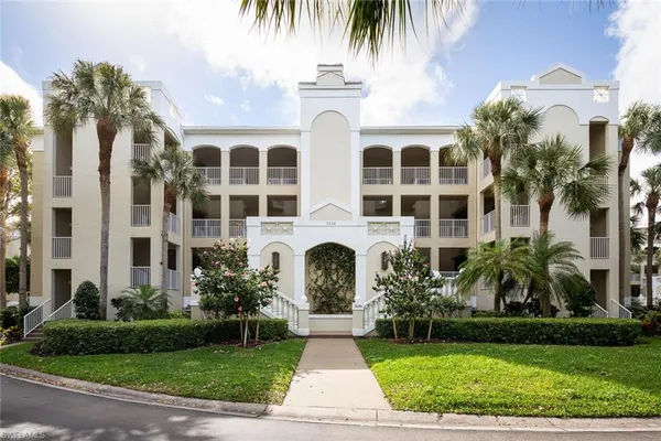 a front view of multi story residential apartment building with yard and green space