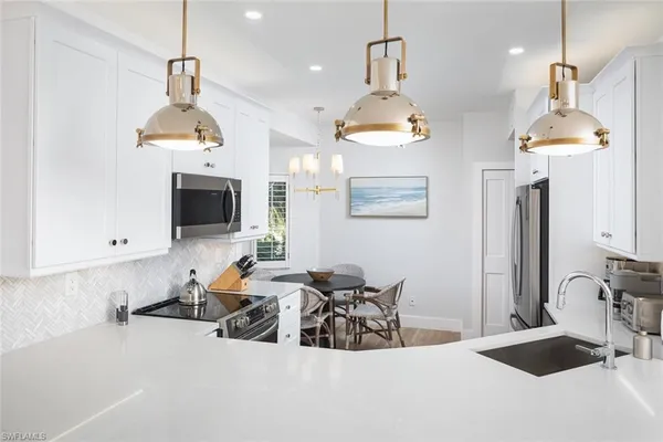 a kitchen with stainless steel appliances a stove sink and microwave