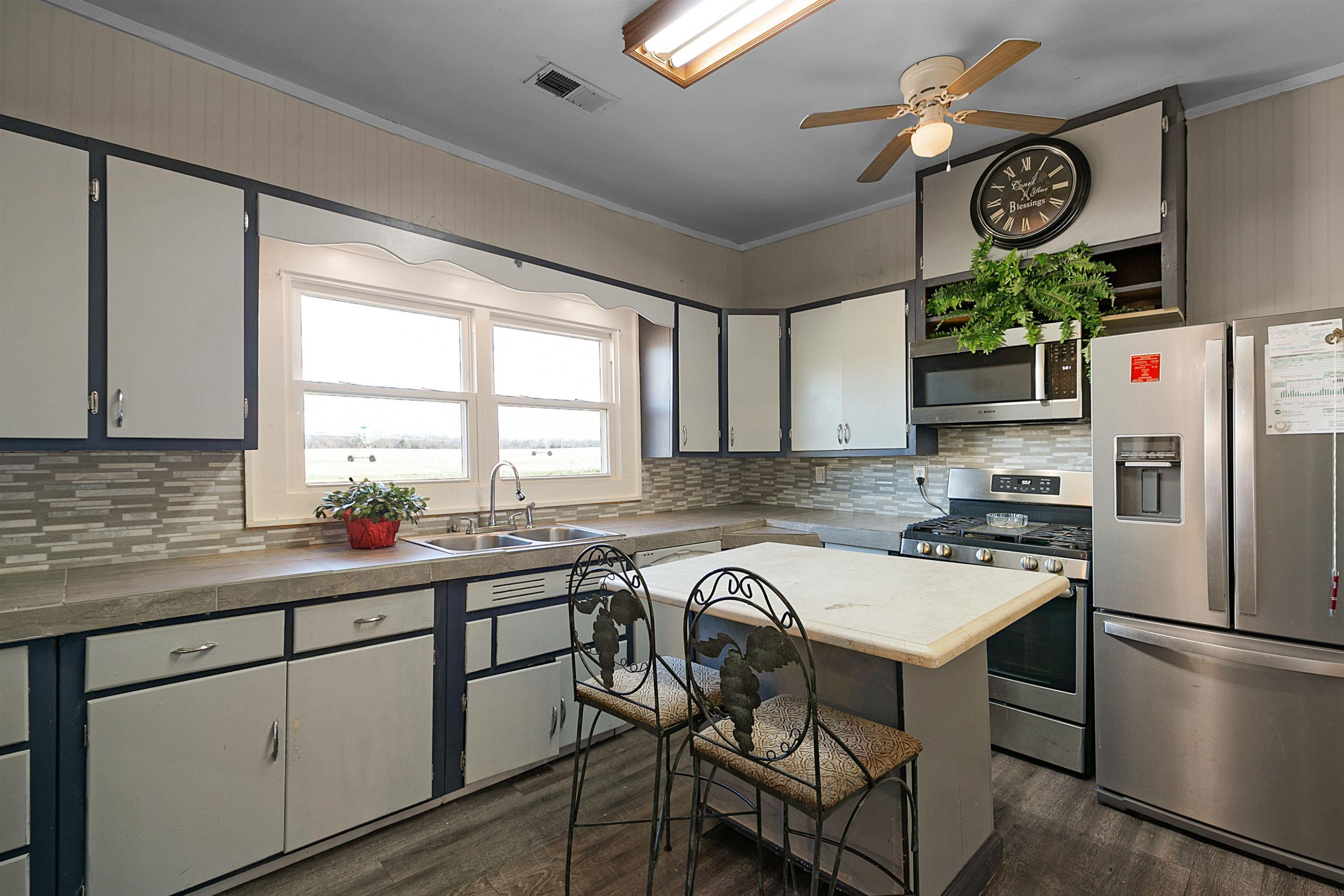 5118 Old Jackson Road Bells, TN 38006 - Photo 3 of 21 a kitchen with stainless steel appliances granite countertop a refrigerator a sink dishwasher a stove and white countertops with wooden floor
