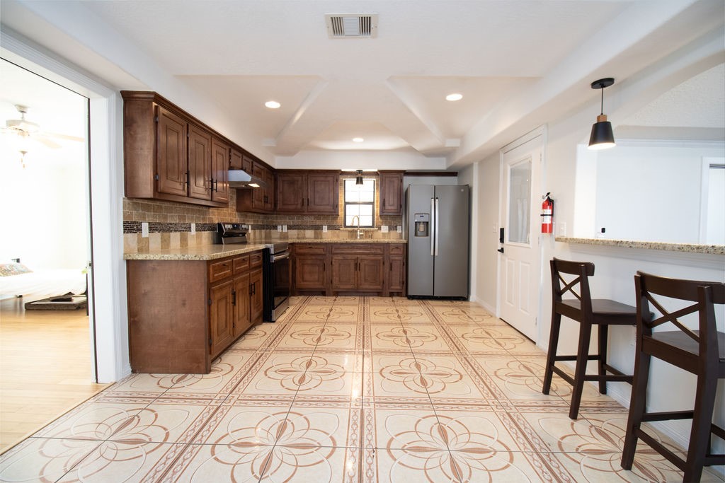 5201 Chapman Street Houston, TX 77009 - Photo 12 of 30 a kitchen with stainless steel appliances granite countertop a refrigerator and a stove top oven