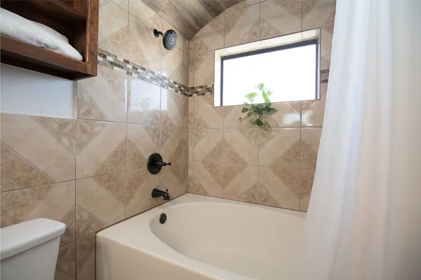 a bathroom with a granite countertop sink toilet mirror vanity and bathtub