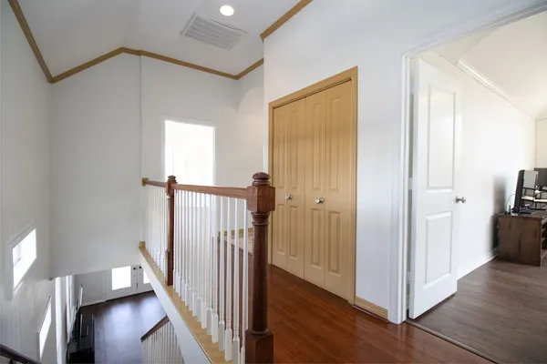 a view of a hallway with wooden floor and entryway