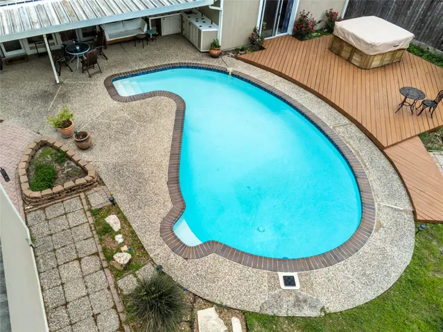 a view of a backyard with swimming pool and plants