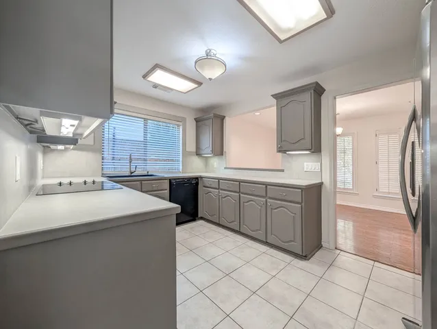 a kitchen with a sink a stove cabinets and counter space