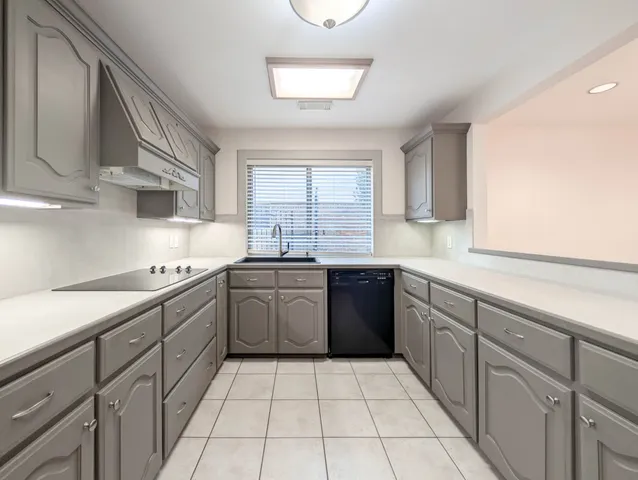 a kitchen with a sink a stove top oven and cabinets