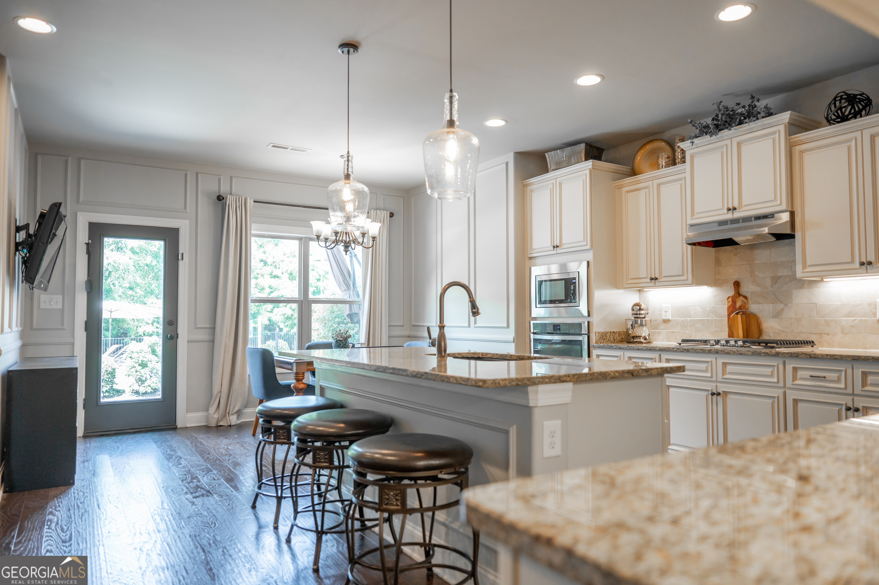 415 EAS Way Fayetteville, GA 30215 - Photo 9 of 70 a kitchen with stainless steel appliances granite countertop a stove top oven a sink dishwasher a dining table and chairs with wooden floor