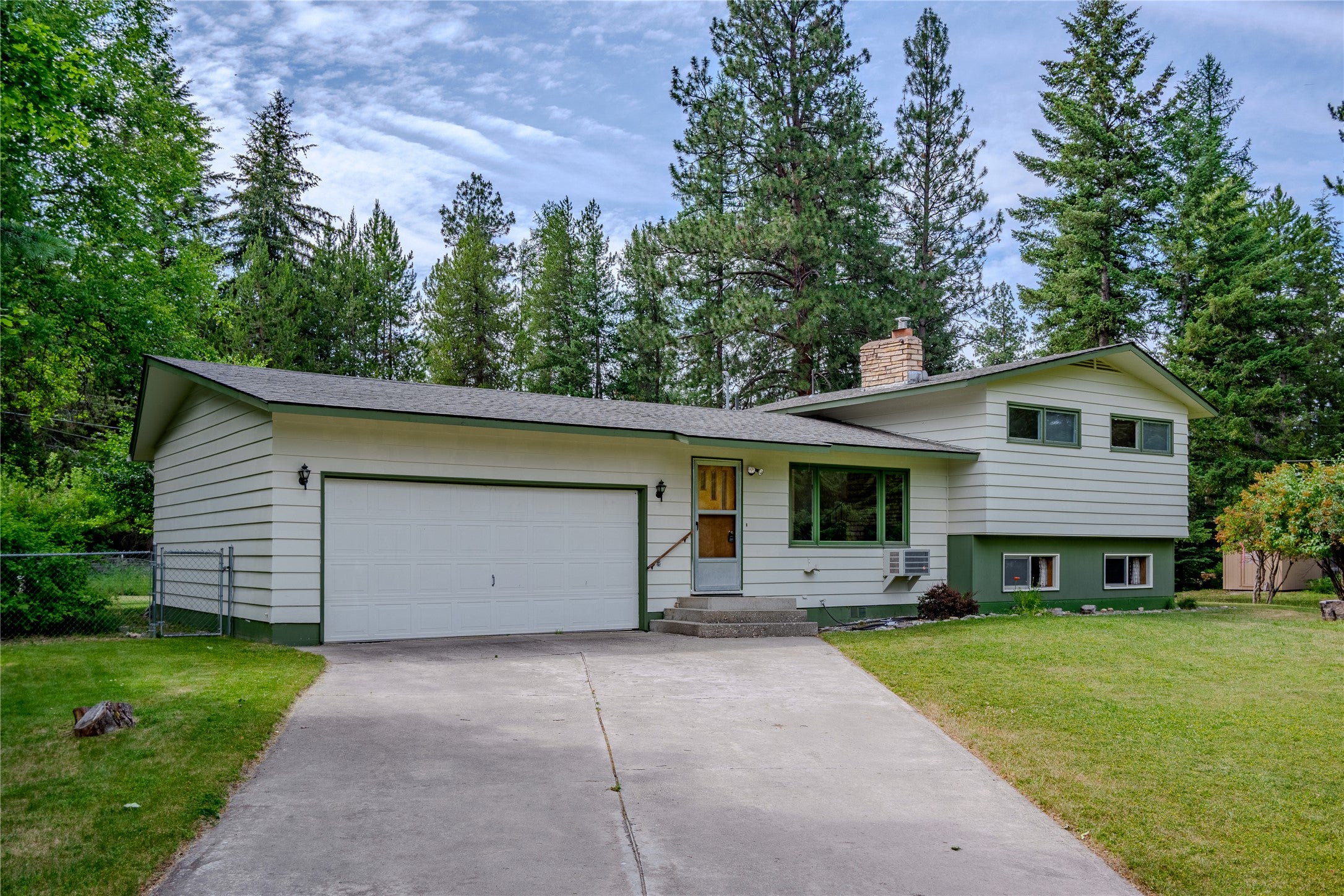 172 Scenery Road Libby, MT 59923 - Photo 1 of 1 Split level home with a chimney, concrete driveway, a garage