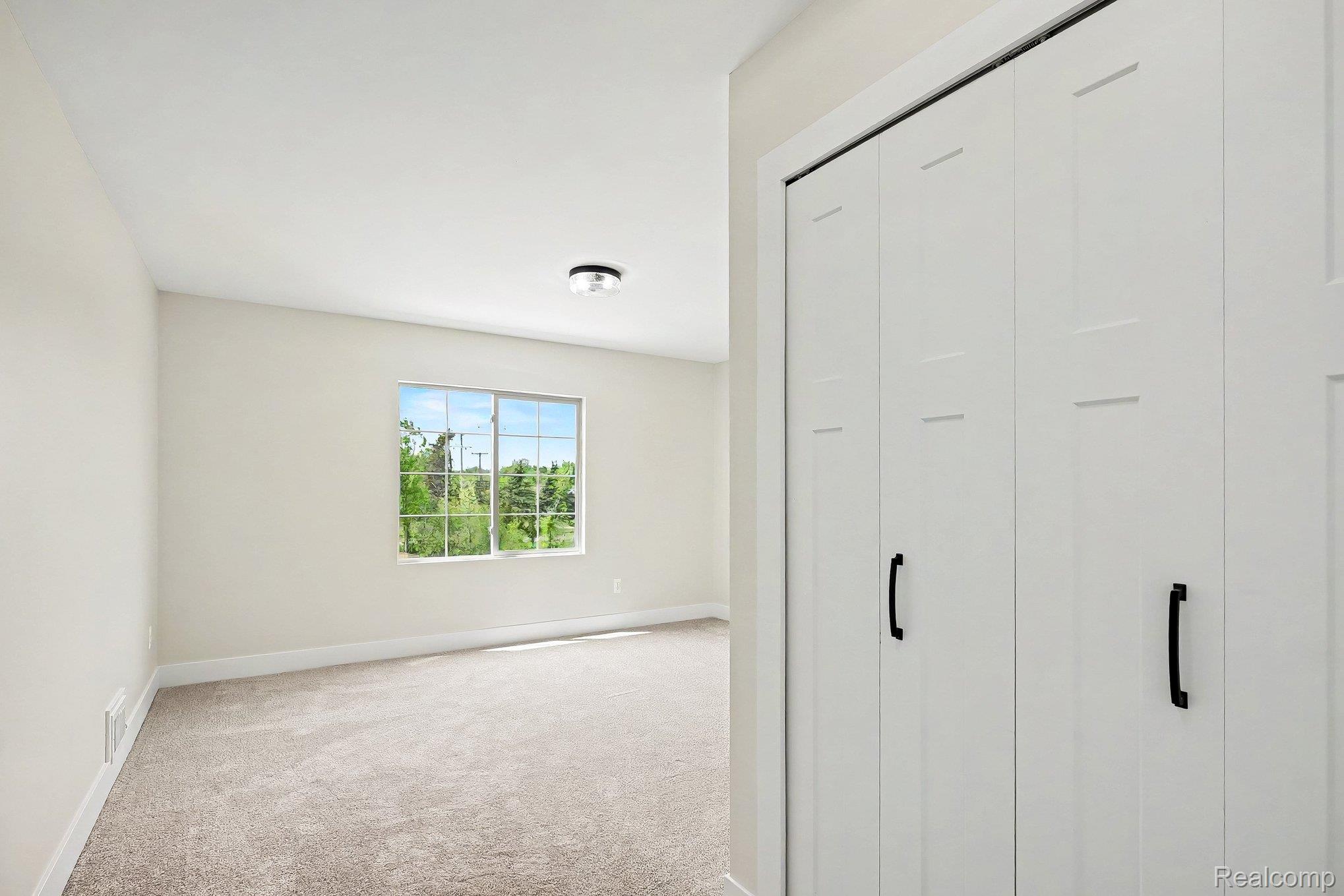 57560 Omo Road Ray, MI 48096 - Photo 27 of 44 Upper level bedroom 3. Spacious room featuring neutral carpeting, light-toned wall paint, and a window with outdoor scenery