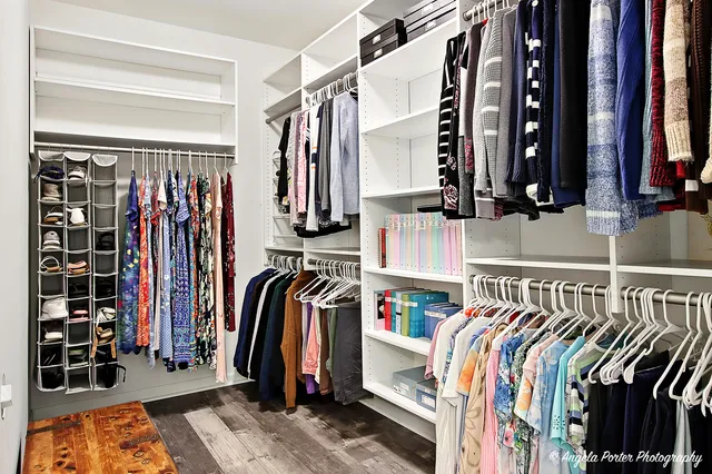 a view of walk in closet with clothes and shoes