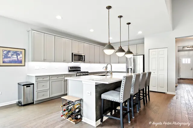 a kitchen with a dining table chairs sink and wooden floor