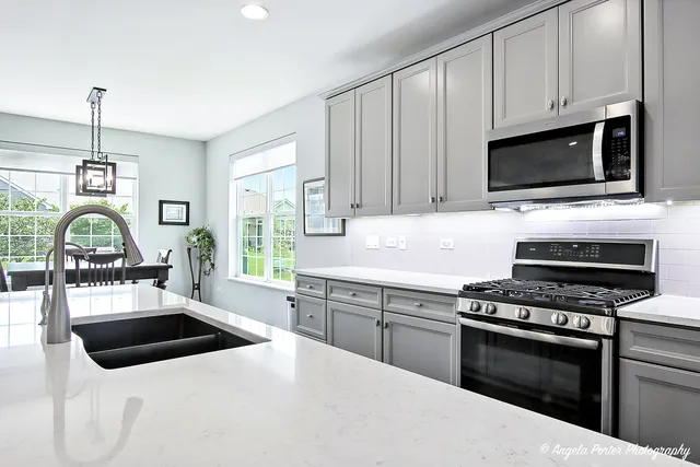 a kitchen with a stove a sink and a microwave