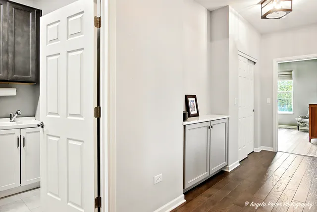 a hallway with white cabinets and wooden floor