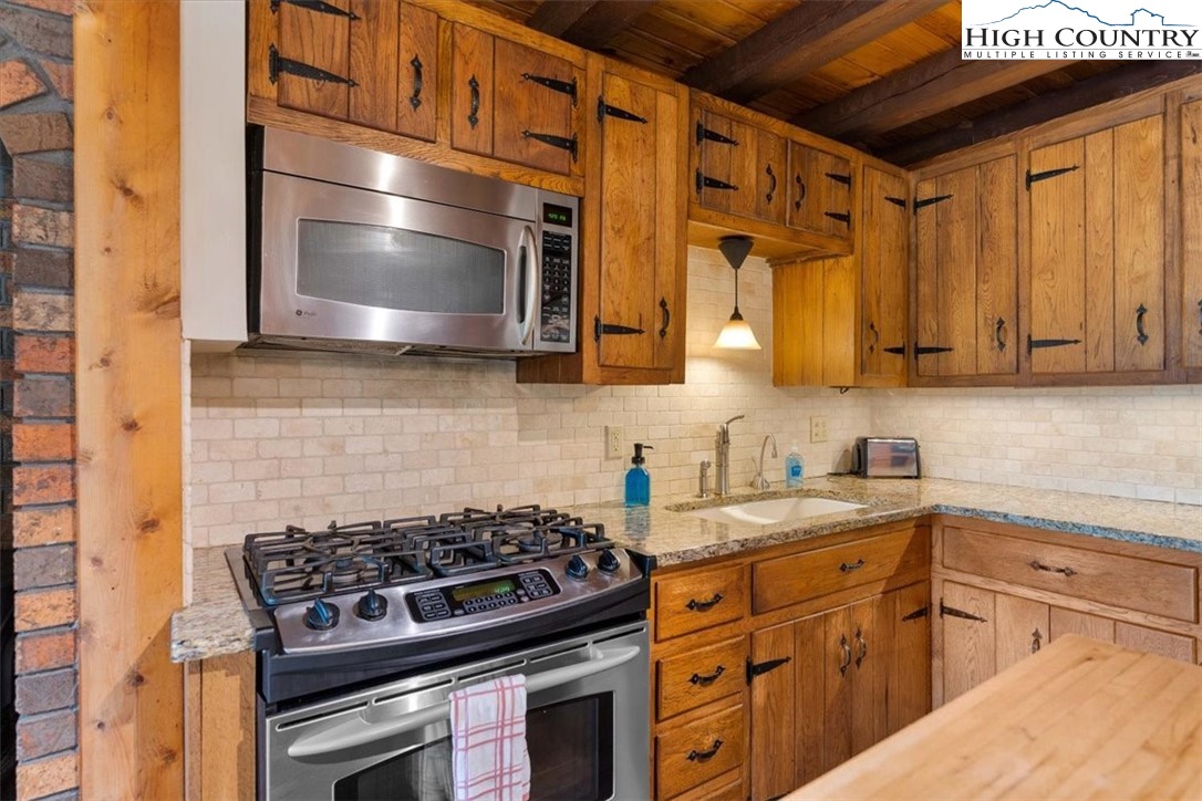 117 Chinkapin Ridge Road Seven Devils, NC 28604 - Photo 11 of 43 a kitchen with stainless steel appliances granite countertop a stove and a microwave