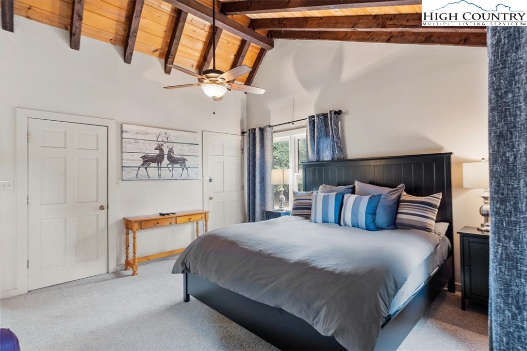 117 Chinkapin Ridge Road Seven Devils, NC 28604 - Photo 22 of 43 a bedroom with a bed and a chandelier