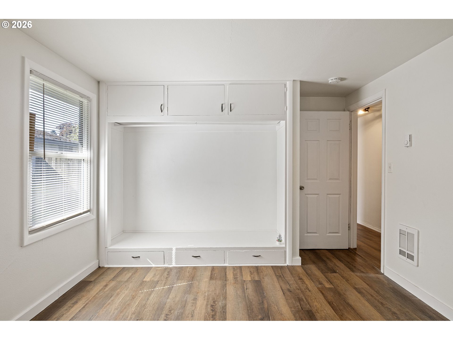 1008 Coburg Road Eugene, OR 97401 - Photo 18 of 46 a view of an empty room with wooden floor and a window