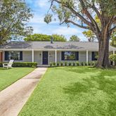 front view of a house and a yard and trees