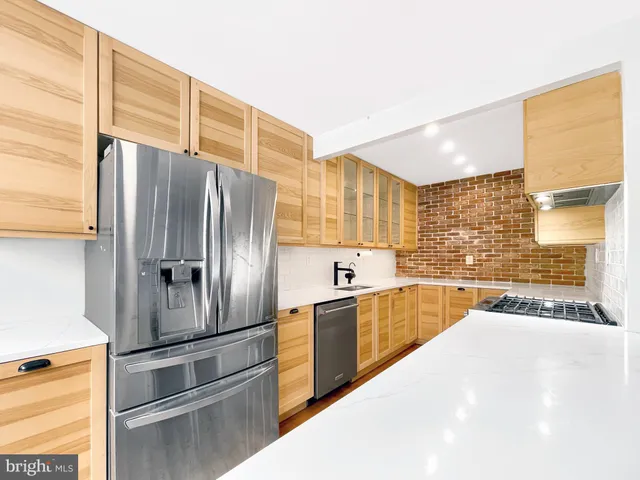 a kitchen with stainless steel appliances granite countertop a refrigerator a sink and dishwasher