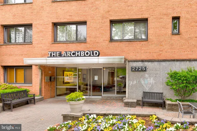 front view of a brick building with a bench in front of building