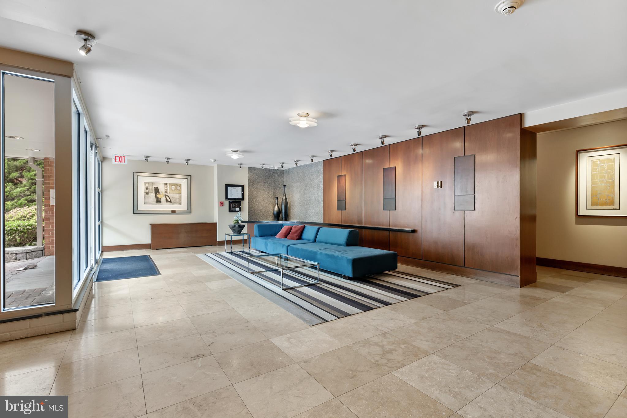 2725 39th Street Northwest, Unit 2O9 Washington, DC 20007 - Photo 22 of 35 a spacious bedroom with a large bed and a chandelier