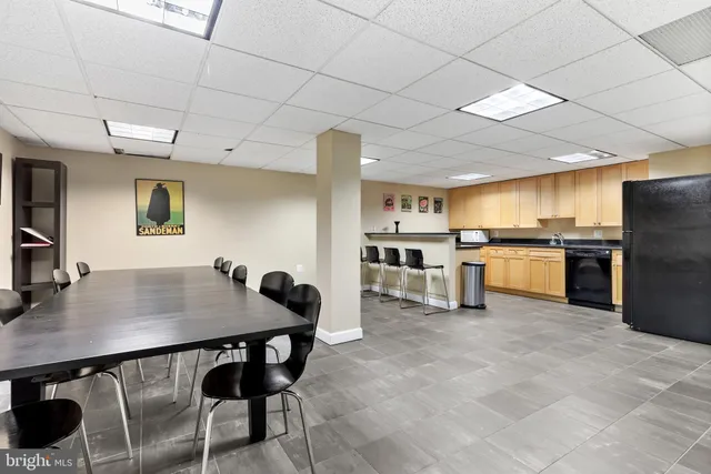 a kitchen with stainless steel appliances kitchen island granite countertop a sink a stove a refrigerator a counter top space and cabinets