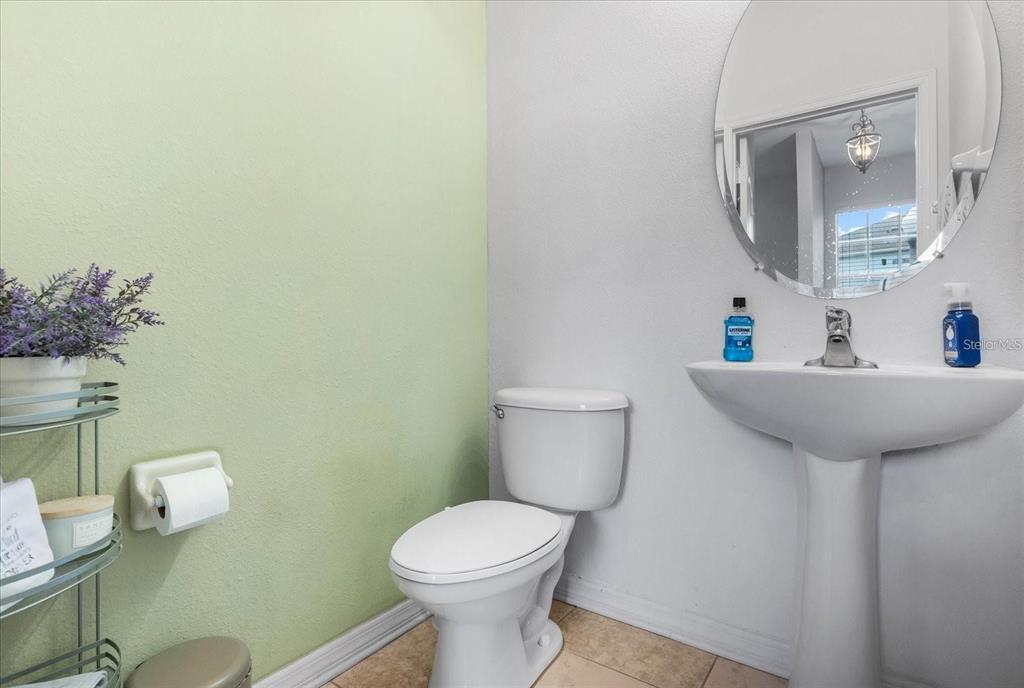 3115 Capri Isle Way Orlando, FL 32835 - Photo 13 of 40 a bathroom with a toilet a sink and mirror