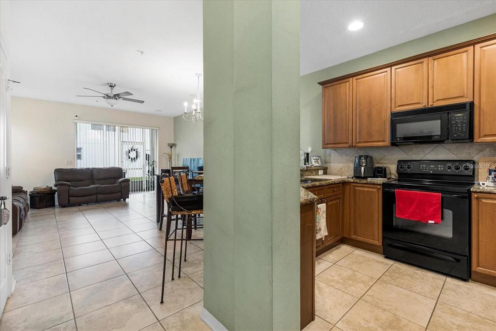 3115 Capri Isle Way Orlando, FL 32835 - Photo 14 of 40 a kitchen with stainless steel appliances a stove sink microwave and cabinets