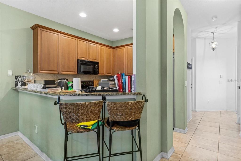 3115 Capri Isle Way Orlando, FL 32835 - Photo 18 of 40 a kitchen with stainless steel appliances granite countertop a stove refrigerator and a microwave