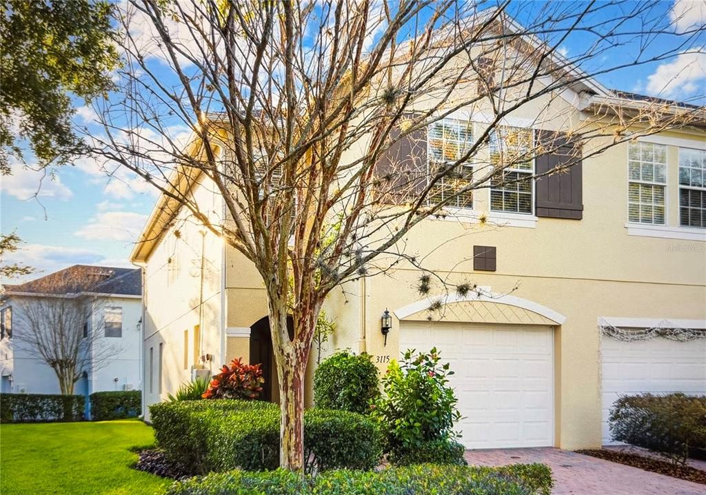 3115 Capri Isle Way Orlando, FL 32835 - Photo 2 of 40 a view of a white house with a large tree