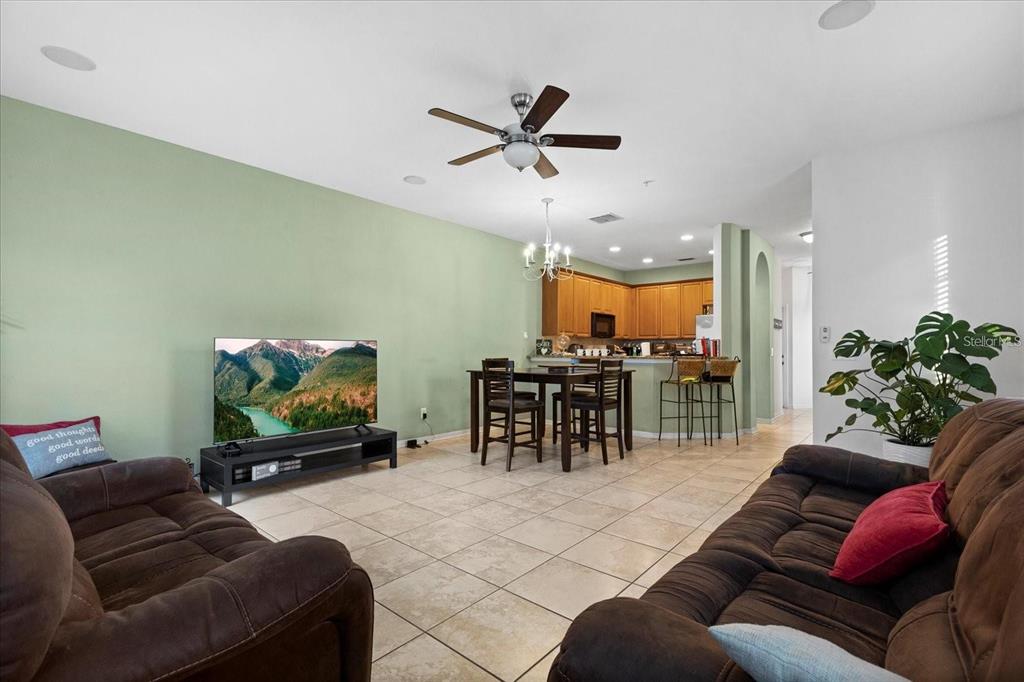 3115 Capri Isle Way Orlando, FL 32835 - Photo 22 of 40 a living room with furniture and a flat screen tv with kitchen view