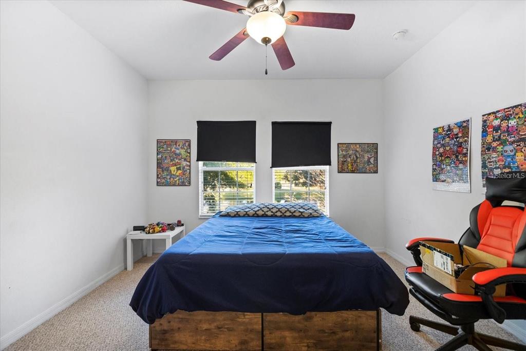 3115 Capri Isle Way Orlando, FL 32835 - Photo 32 of 40 a bed sitting in a bedroom next to a window with a flat screen tv and a chandelier
