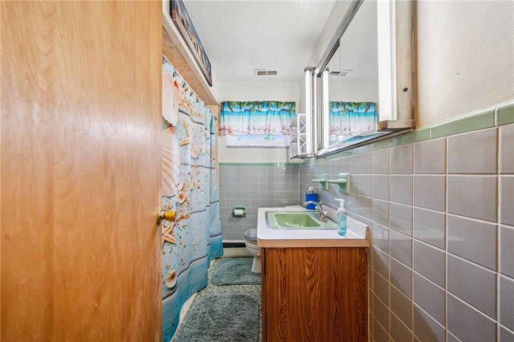 974 Renton Road Pittsburgh, PA 15239 - Photo 17 of 48 a bathroom with a sink and a mirror