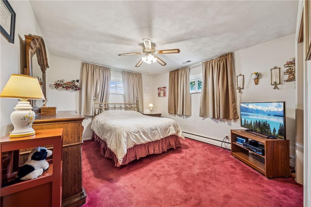 974 Renton Road Pittsburgh, PA 15239 - Photo 18 of 48 a spacious bedroom with a bed and a chandelier