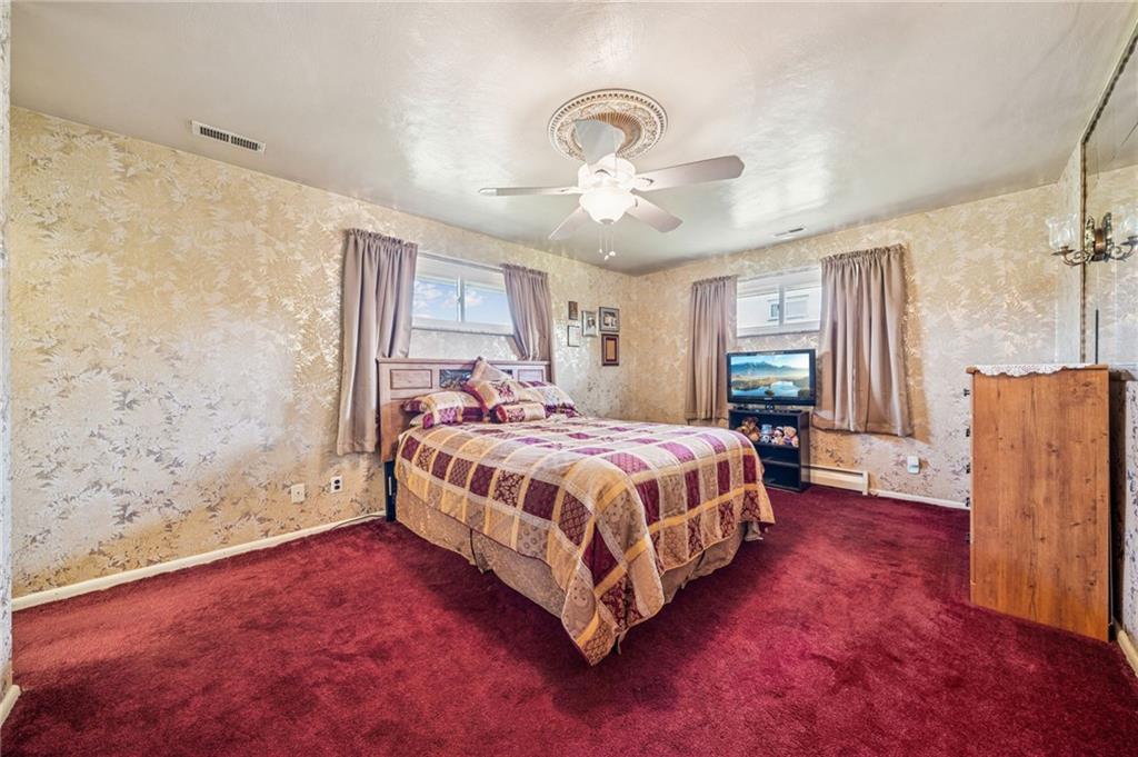 974 Renton Road Pittsburgh, PA 15239 - Photo 20 of 48 a spacious bedroom with a bed and a chandelier