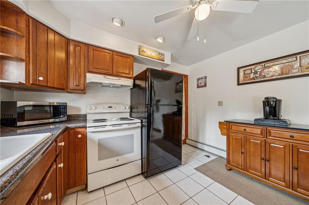 974 Renton Road Pittsburgh, PA 15239 - Photo 3 of 48 a kitchen with stainless steel appliances granite countertop a stove a refrigerator and a sink dishwasher with wooden cabinets