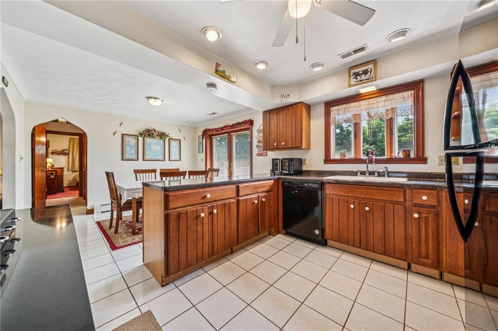 974 Renton Road Pittsburgh, PA 15239 - Photo 4 of 48 a large kitchen with stainless steel appliances granite countertop a refrigerator a sink dishwasher a dining table and chairs with wooden floor