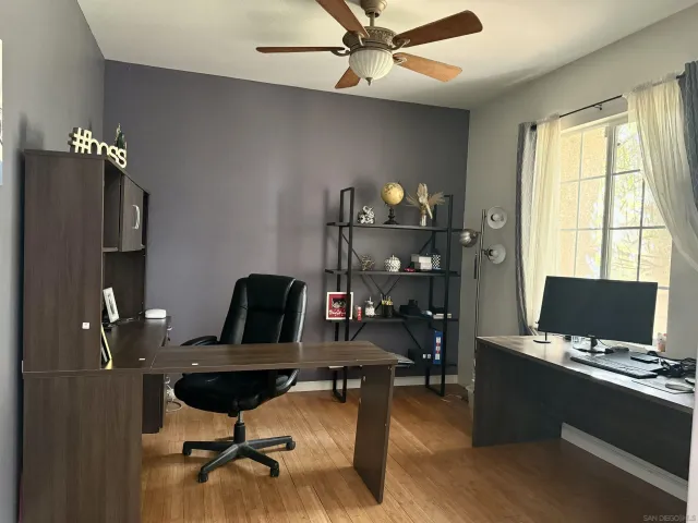 a view of a workspace with furniture and a window