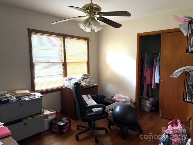 a view of a workspace with furniture and a window