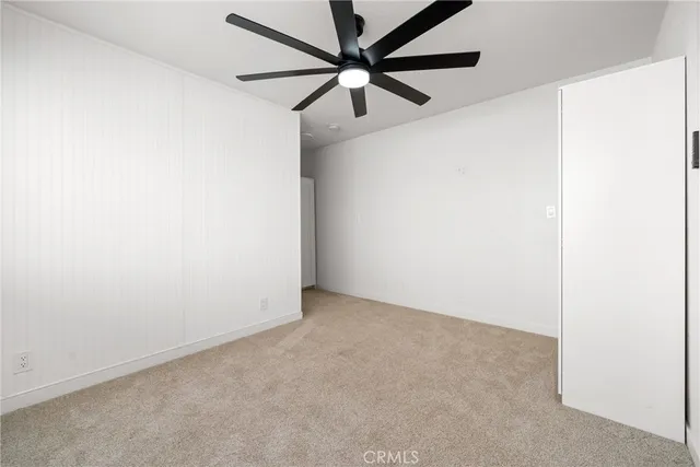 an empty room with a ceiling fan and a window