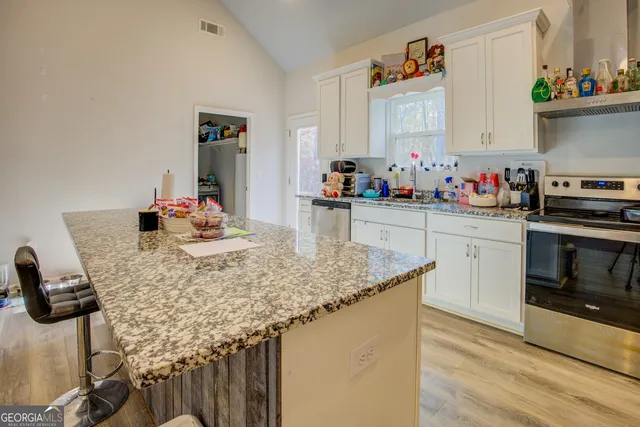 a kitchen with stainless steel appliances granite countertop a sink stove and cabinets