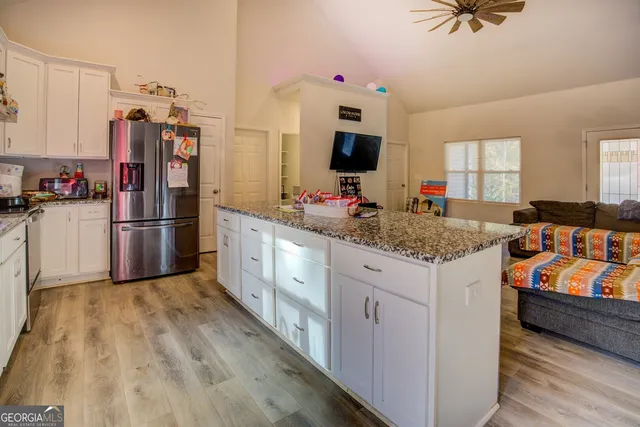 a kitchen with refrigerator cabinets and wooden floor