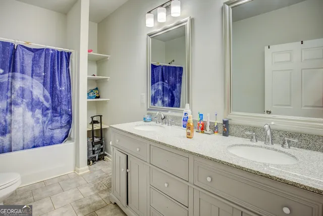a bathroom with a granite countertop sink mirror vanity and bathtub