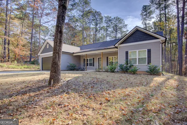 a view of a house with a yard and large tree