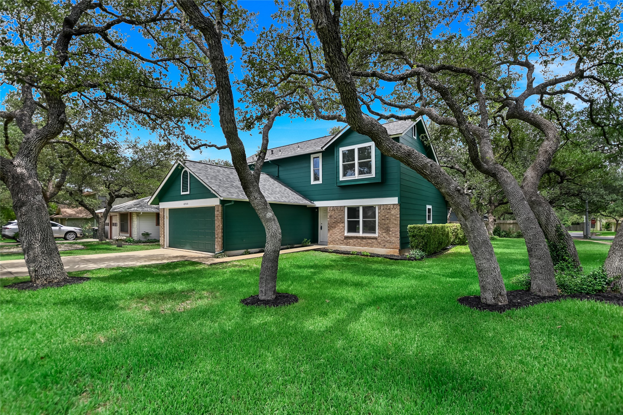 6900 Tesoro Trail Austin, TX 78729 - Photo 1 of 1 Traditional-style house with brick siding, an attached garage, a front yard, driveway, and roof with shingles