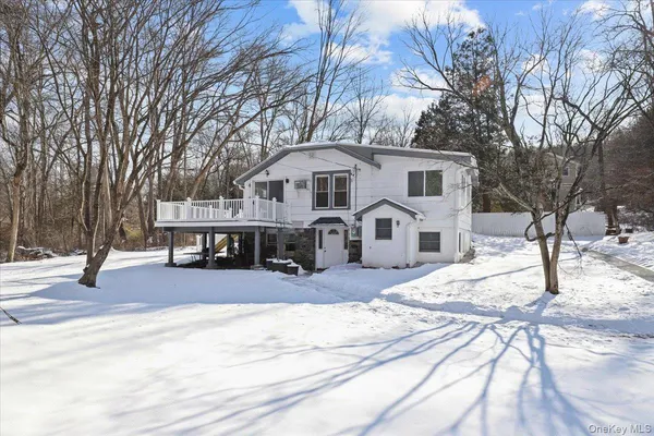 a front view of a house with a yard covered in snow