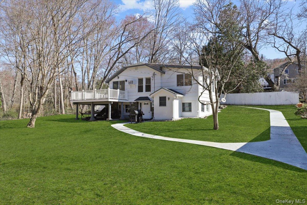 a front view of a house with a garden and trees