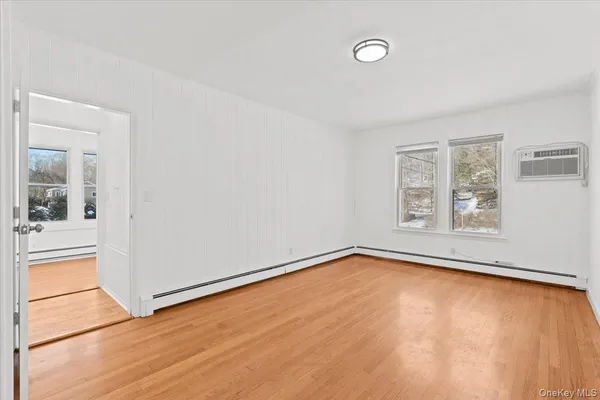 a view of a room with wooden floor and a window